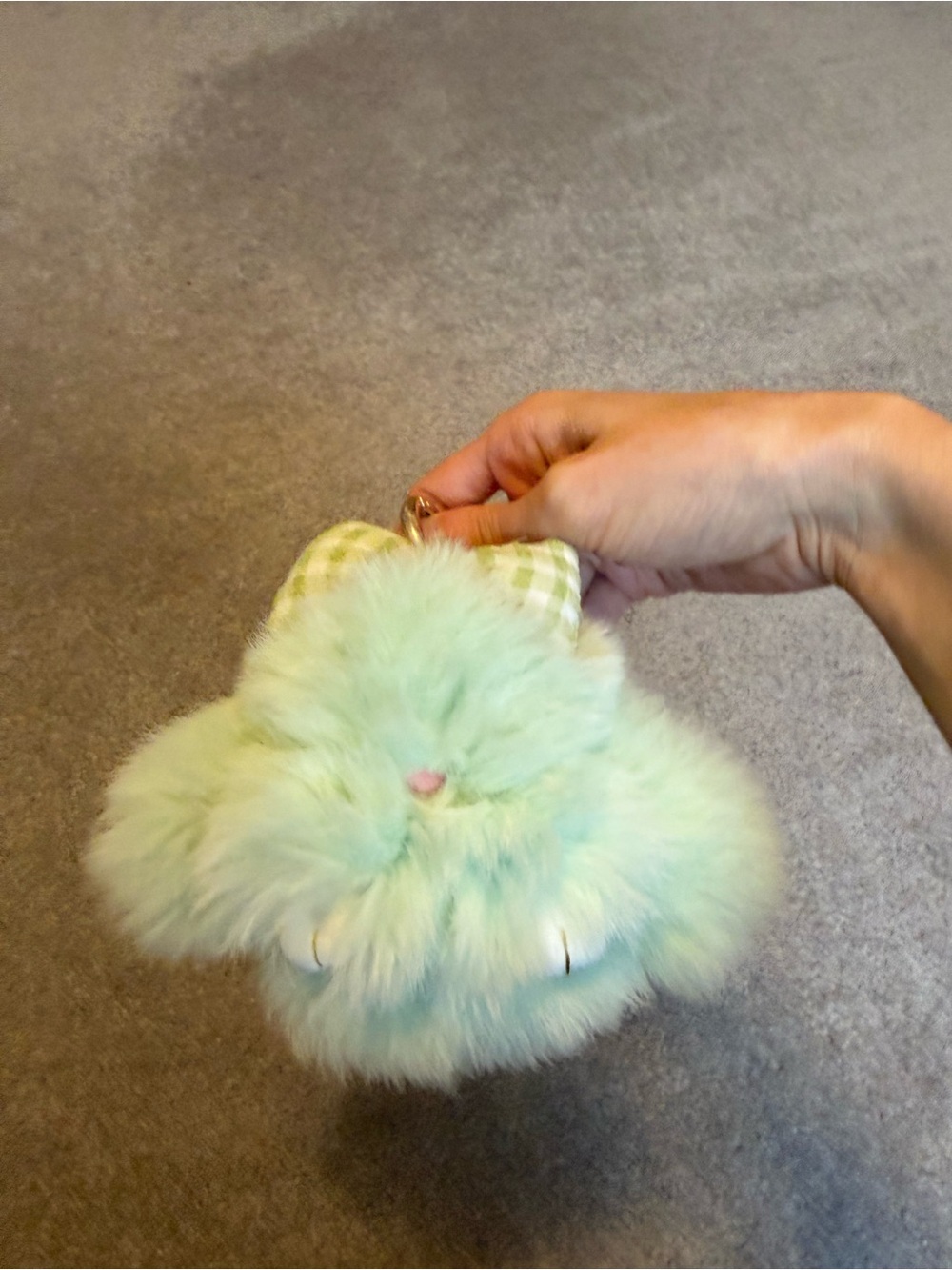 Light green furry bunny keychain with a bow